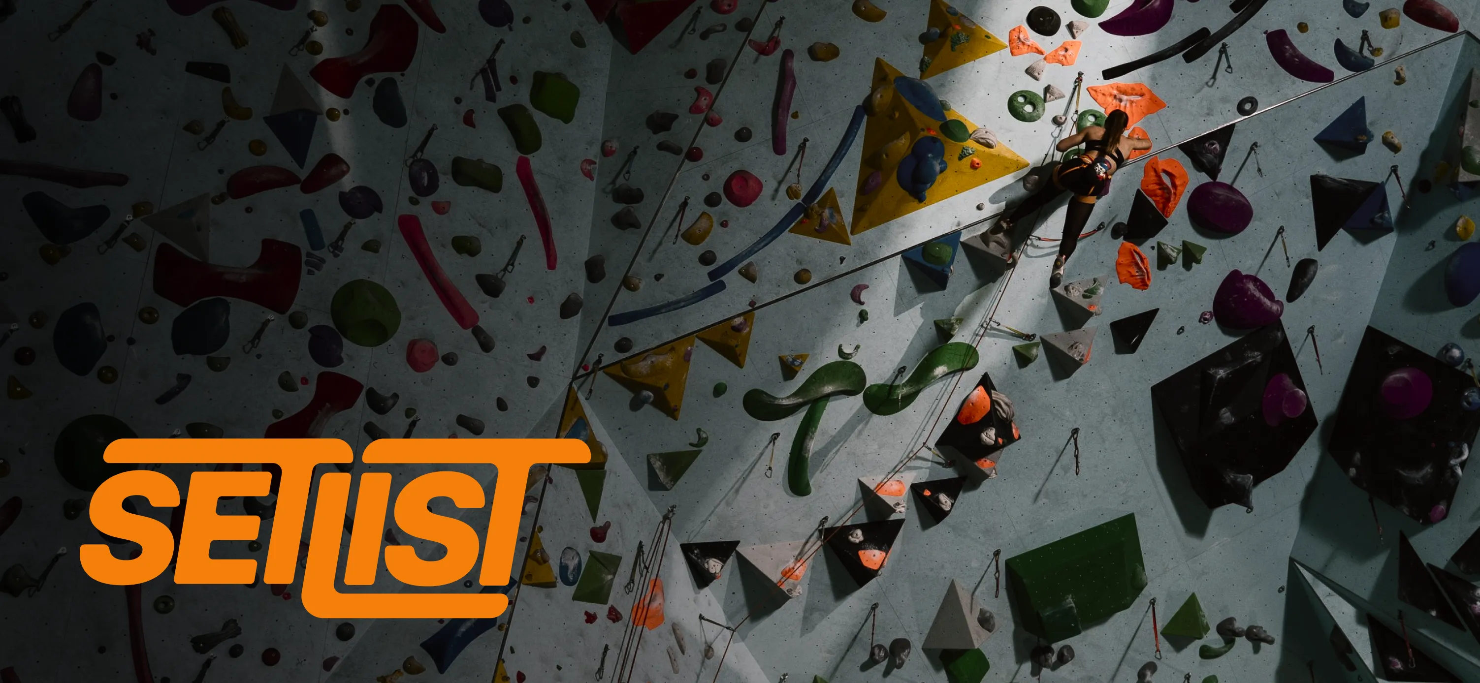 A QR tag mounted on a climbing hold, with the Setlist logo overlaid on the wall